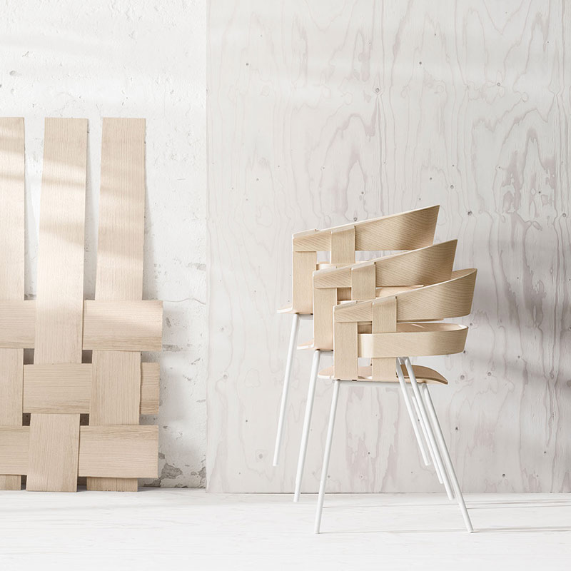 Three stacked chairs next to a decor with an overlapping design