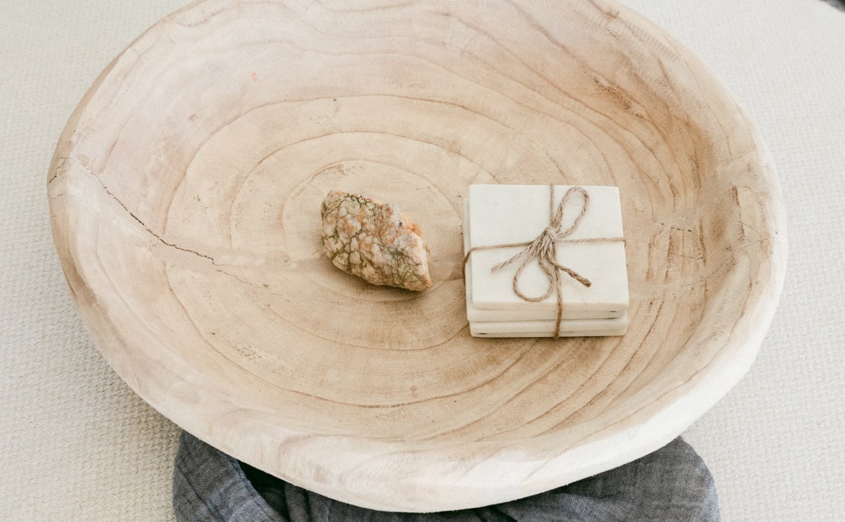 A wooden bowl with a stone and gift box